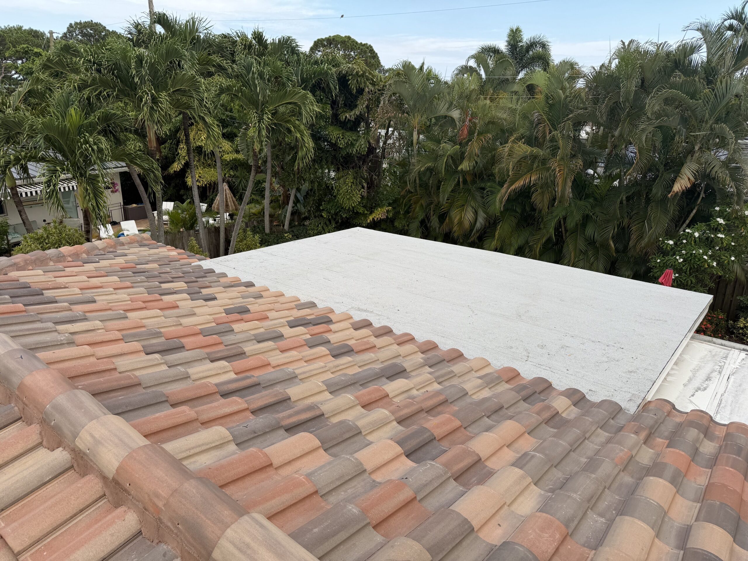Tile roof meeting flat roof section on completed Wilton Manors job