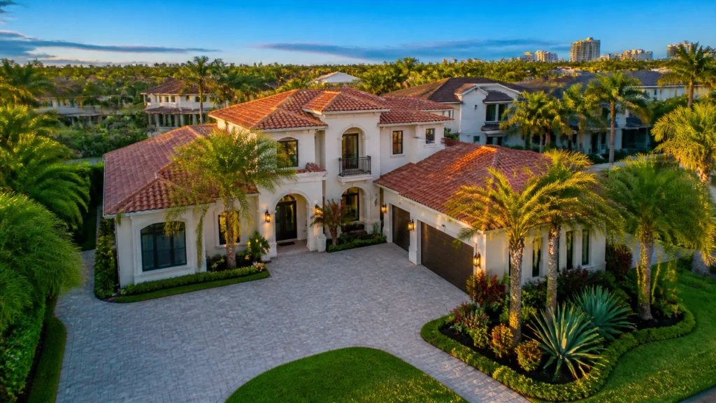Two-story Mediterranean-style home with a clay tile roof and paver driveway